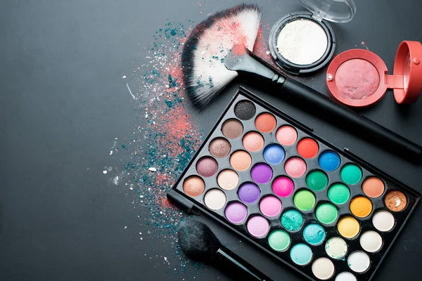 Üstten Görünüm. Dekoratif kozmetik ve makyaj fırçaları koyu arka plan üzerinde set