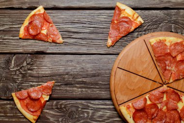 Ev yapımı sucuk ve dilim pizza ahşap bir masa üzerinde. Üstten Görünüm.