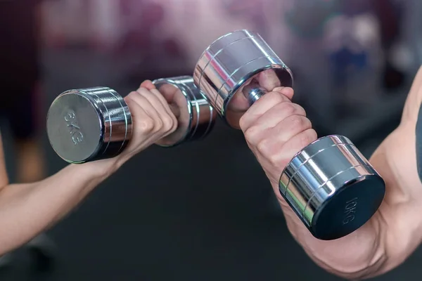 Weights in male and female hand — Stock Photo, Image