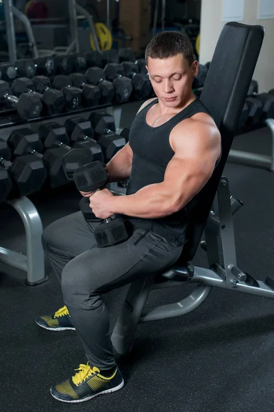 Athletic man in gym doing exercises — Stock Photo, Image