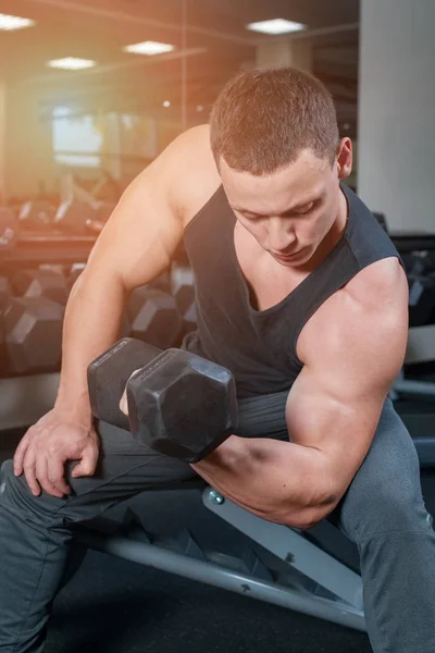 Sports koncept. Bodybuilder i gym tränar med hantlar — Stockfoto