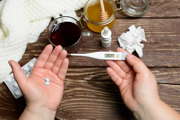 Tratamiento de la gripe y los resfriados. Manos femeninas con termómetro . — Foto de Stock