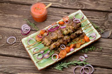 Domuz eti ve koyu ahşap masa salataya şiş kebap.