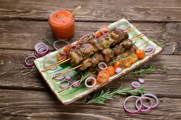 Domuz eti ve koyu ahşap masa salataya şiş kebap.