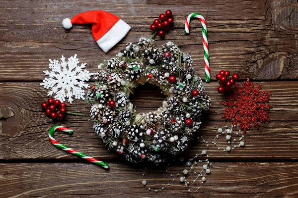 Navidad. Corona de Navidad de conos de abeto y accesorios en la mesa de madera — Foto de Stock