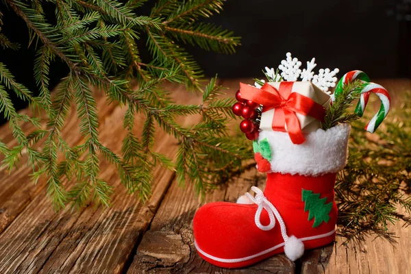 Las botas de Santa Claus con decoraciones en una mesa de madera — Foto de Stock