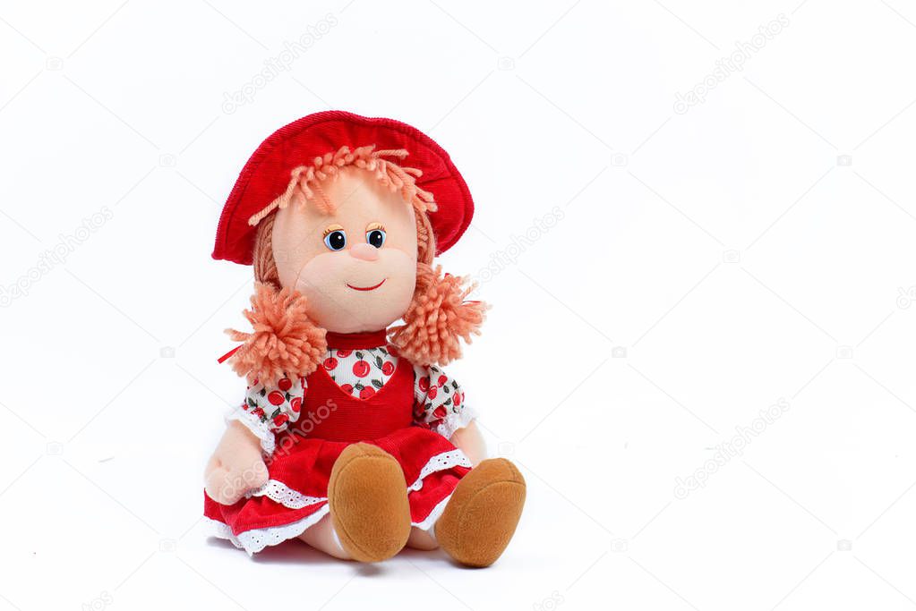 Soft doll in red hat and dress on white background