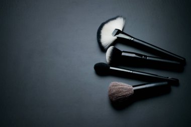Karanlık bir arka plan üzerinde makyaj için fırçalar