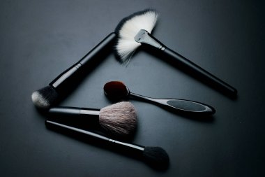 Karanlık bir arka plan üzerinde makyaj için fırçalar