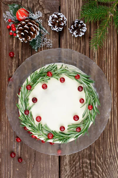 Krem peynir frosting ile Noel için ev yapımı kek dekore biberiye ve ahşap bir masa üzerinde çilek ile