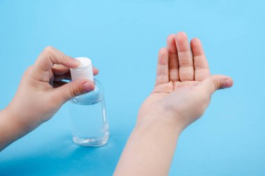 Elinde antibakteriyel jel olan bir şişe.