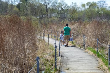 Saint Paul, Minnesota-Mayıs 2018: Baba ve iki oğlu tahta üzerinde bahar döneminde yürüyüş.