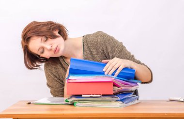 Kız düşünceli bir yığın masada klasörlerinin ofis çalışanı geçer