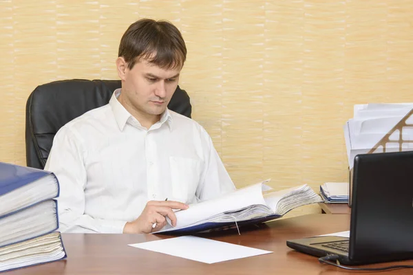 Человек за столом в офисе для просмотра документов — стоковое фото