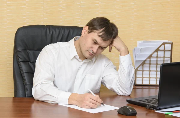 Mannen på kontoret i tabellen skriver på papper — Stockfoto