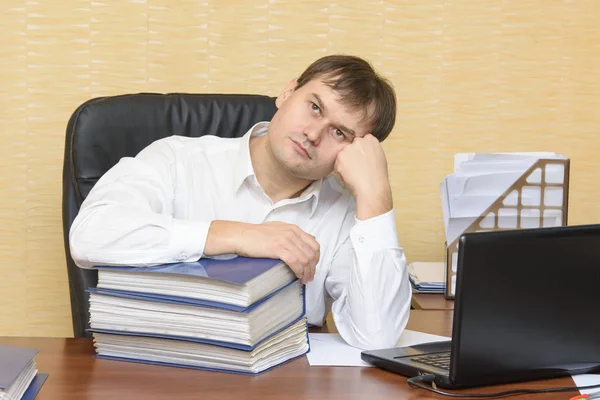 De man aan de balie in de office-denken Stockafbeelding