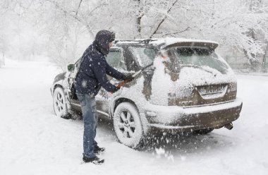 Volgograd. Rusya-Ocak, 16, 2017-bir adam bir kar yağışı sırasında arabasında kar temizler