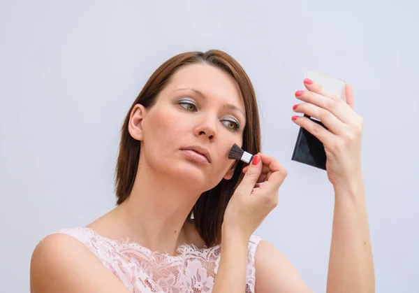 stock image Young woman applies powder to the face