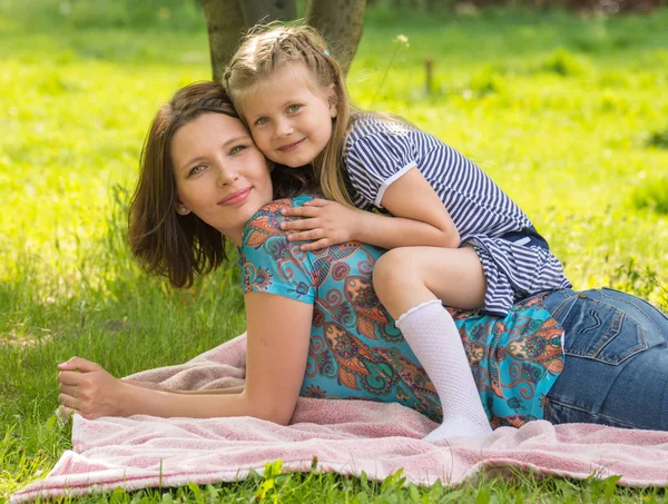 Mladá žena s 6 - ti letá holčička v kvetoucího parku — Stock fotografie