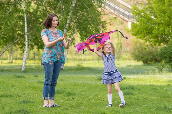 Mladá žena s 6 - ti letá holčička létání draka v zeleném parku — Stock fotografie