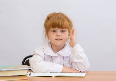 Küçük kız elini cevap için yetiştirme Okulu masa başında oturur