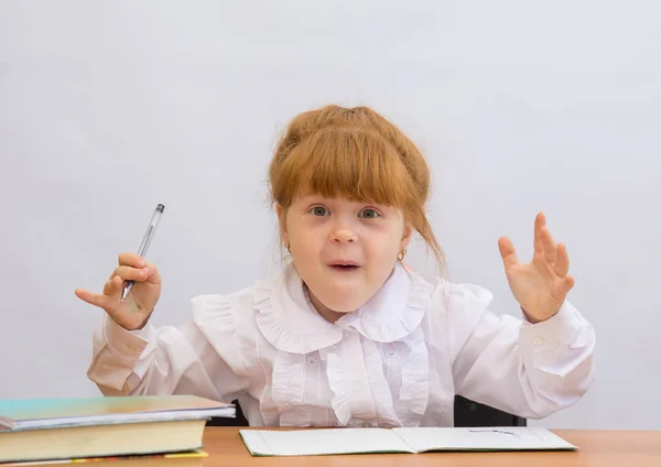 Niña en el escritorio gritando alegremente, manos arriba —  Fotos de Stock