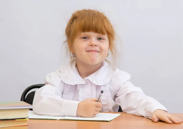 Menina na mesa sorrindo — Fotografia de Stock