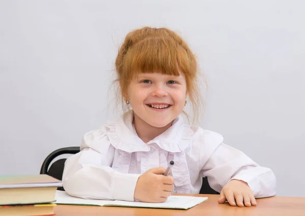 Маленька дівчинка за столом весело сміється — стокове фото
