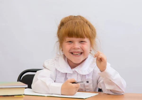 Menina na mesa alegremente ri — Fotografia de Stock