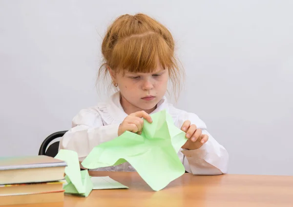 A menina na mesa com concentração faz Paper Airplane — Fotografia de Stock