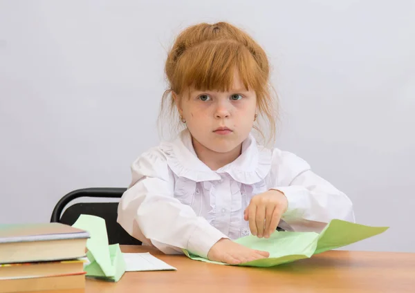 La niña en la mesa con concentración hace que Paper Airplane —  Fotos de Stock