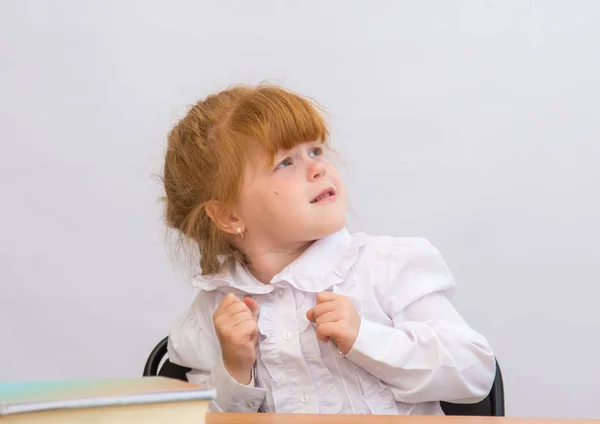 A menina na mesa olhando para cima assustada — Fotografia de Stock