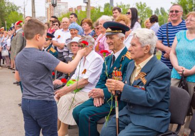 Volgograd. Rusya - 8 Mayıs 2018. Bir genç çiçek büyük Vatanseverlik Savaşı gazileri için eller.