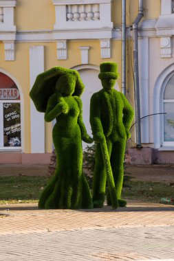 Astrakhan. Rusya-8 Kasım 2019. Yapay ottan yapılmış çim figürleri. Caddedeki Atrium İdari ve Büro İş Merkezi 'nin yakınındaki Bayan ve Centilmen. Kirov