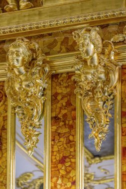 St. Petersburg, Rusya - 24 Şubat 2020: Catherine Sarayı 'ndaki yenilenmiş Amber Odası' nın (Amber Odası) kehribar duvarında kadın başı ve çiçek süsü şeklinde altın süslemeler.