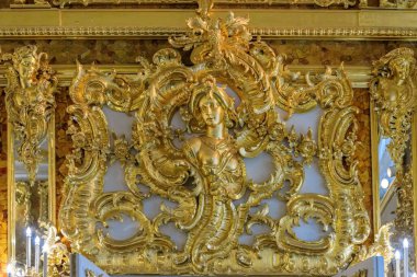 St. Petersburg, Rusya - 24 Şubat 2020: Catherine Sarayı 'ndaki yenilenmiş Amber Odası' nın (Amber Odası) kehribar duvarında kadın başı ve çiçek süsü şeklinde altın süslemeler.