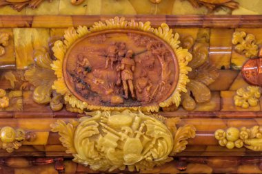 ST. PETERSBURG, RUSSIA - February 24, 2020: Details of the magnificent carving on amber wall panels in the restored Amber Room (Amber Chamber) in the Catherine Palace of Tsarskoye Selo. clipart