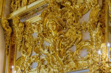 St. Petersburg, Rusya - 24 Şubat 2020: Catherine Sarayı 'ndaki yenilenmiş Amber Odası' nın (Amber Odası) kehribar duvarında kadın başı ve çiçek süsü şeklinde altın süslemeler.