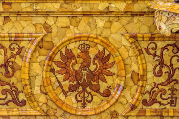ST. PETERSBURG, RUSSIA - February 24, 2020: Detail view of the eagle coat of arms of the Prussian kings on amber wall panels in the restored Amber Room (Amber Chamber) in the Catherine Palace.