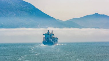 Yalnız konteynır gemisi yoğun deniz sisi içinde hareket ediyor. Görüş mesafesi kısıtlı..