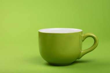 Bir tam büyük kahve çay fincanı yeşil kağıt üzerinde