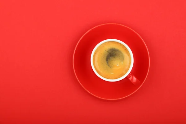 Один кофе эспрессо в чашке с блюдцем на красном — стоковое фото