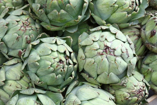 Green fresh globe artichokes on market display — Stock Photo, Image