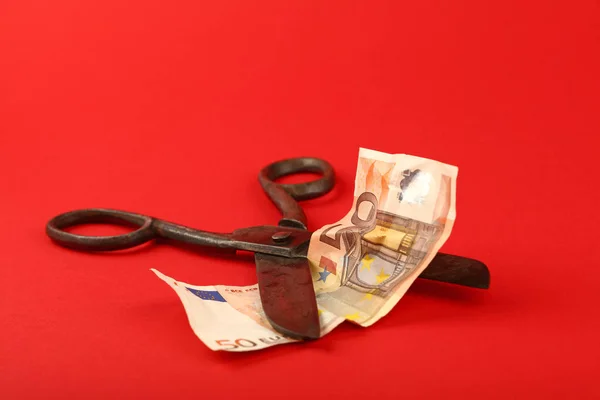 Scissors cut Euro banknote over red background — Stock Photo, Image