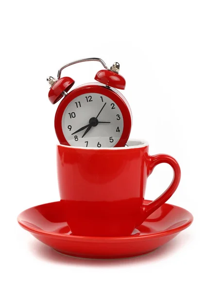 Relógio de alarme vermelho na xícara de café sobre branco — Fotografia de Stock