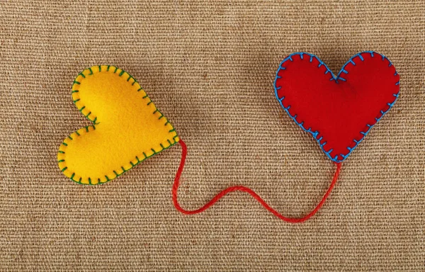 Два войлочных сердца, желтое и красное на пушках — стоковое фото