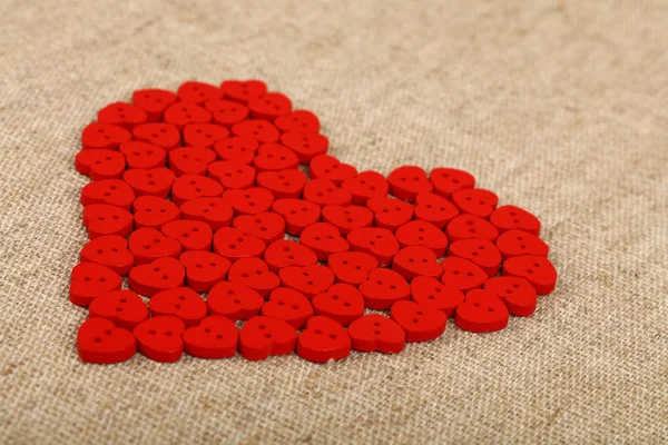 Кнопки в форме красного сердца на холсте — стоковое фото