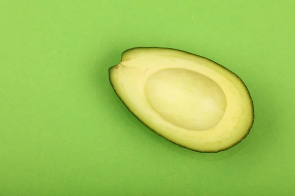 Frische reife Avocado auf grünem Papier — Stockfoto