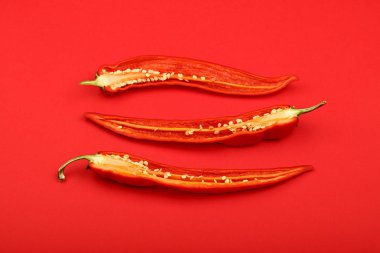 Üç kırmızı zemin üzerine sıcak biber kesmek