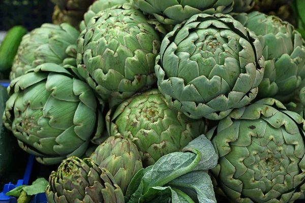 Green fresh globe artichokes on market display — Stock Photo, Image